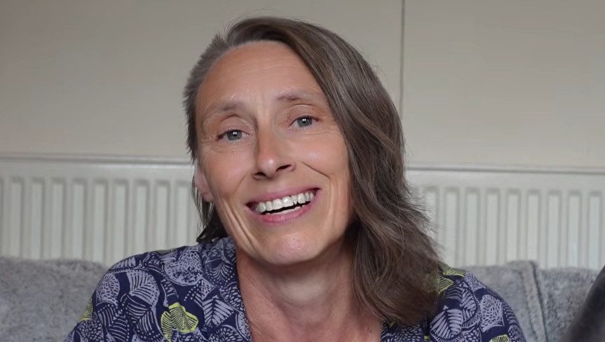 Janet Mason smiling on her sofa during the NRG Mission: On the Street interview
